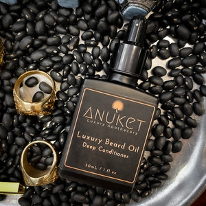 Luxury beard oil bottle laying on a coffee beans dish with gold rings in the background