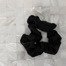 Charger l'image dans la galerie, Black satin Scrunchie displayed on a white tile background