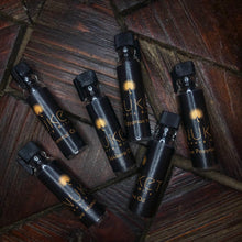Load image into Gallery viewer, Six small sample bottles of Anuket fragrance oils on dark wooden background