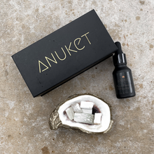 Charger l'image dans la galerie, Pure papyrus diffusing oil, black Anuket box and gold glided oyster holding white selenite stones displayed on stone surface