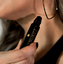 Load image into Gallery viewer, Woman holding Pure Mimose Roll-On Fragrance bottle in her hand towards her neck