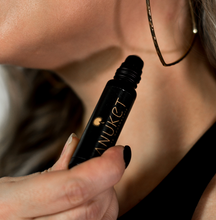 Load image into Gallery viewer, Woman holding Pure Egyptian Rose Roll-On Fragrance bottle in her hand towards her neck