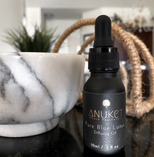 Charger l'image dans la galerie, Pure Blue Lotus Diffusing Oil bottle next to a white marble bowl and straw décor in the background