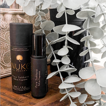 Charger l'image dans la galerie, Pure Sakkara roll on fragrance bottle and box displayed on eucalyptus branch and wood background