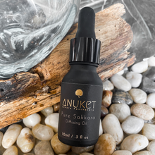 Load image into Gallery viewer, Pure Sakkara diffusing oil bottle laying on a log of wood and mother pearl dish on a stone surface
