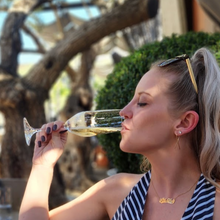 Load image into Gallery viewer, Anuket owner drinking champagne wearing gold ribbon earrings