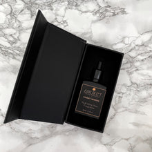 Load image into Gallery viewer, Hydrating hair fragrance bottle inside an opened black box on a white marble background