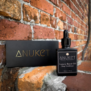 Luxury beard oil deep conditioning bottle and black Anuket box displayed on a brick background