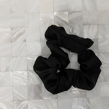 Load image into Gallery viewer, Black satin Scrunchie displayed on a white tile background