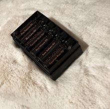 Charger l&#39;image dans la galerie, Black box containing Six fragrance oils on a white faux fur background
