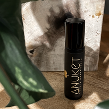 Load image into Gallery viewer, Pure Sakkara Roll-on fragrance bottle on a wooden background with leaf in the corner