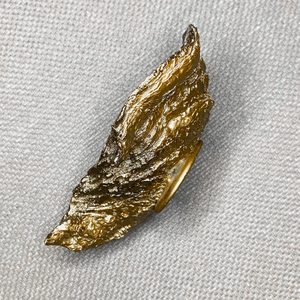 Gold glided oyster side displayed on a light taupe background