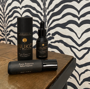 Pure papyrus diffusing oil, pure papyrus Roll-on fragrance and box on a wooden surface and zebra striped background
