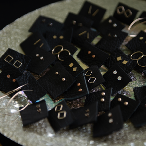 Anuket stud earrings packaged individually and displayed in a sparkly dish
