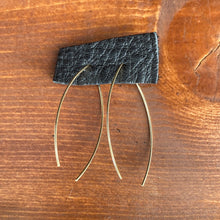 Load image into Gallery viewer, Gold marquise earrings attached to a black leather piece displayed on a wooden background