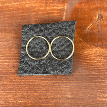 Load image into Gallery viewer, Gold open circle stud earring displayed on black leather piece on a wooden background